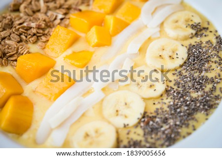 Close up of a Smoothie bowl with Banana, coconut, mango, granola and chia seeds