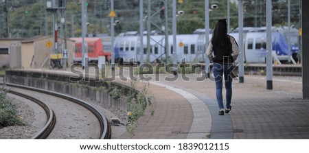 Young Asian woman at a railway station waiting for the train - urban photography