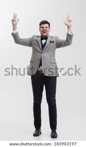 European businessman in triple suit. Handsome man. Euro logo icon pinned to the suit. Mandoing hand gestures. A man raises his hands up.