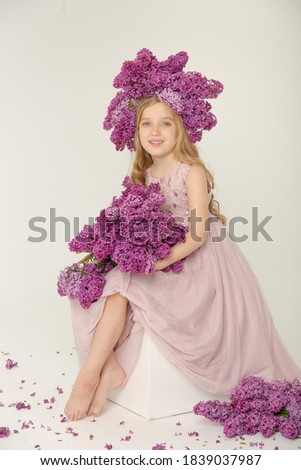 Little cute bright girl in the studio with lilac