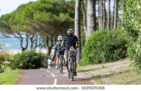 people riding a bicycle on a bike path