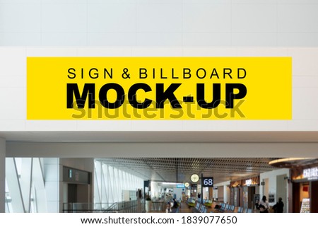 Mock up blank horizontal billboard with clipping path on ceiling over passage of airport terminal. Empty space for insert advertising, announcement or information 