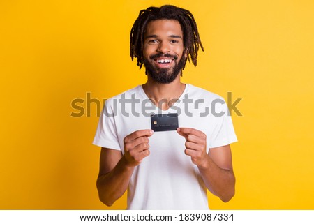 Photo of black guy hold demonstrate debit card look camera wear white t-shirt isolated yellow color background