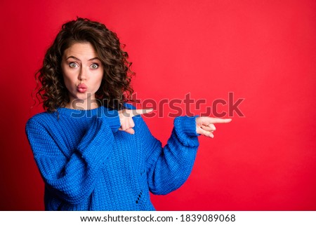 Photo of lovely pretty lady curly hairstyle direct indicate forefingers empty space lips pouted childish staring look wear blue knitted sweater pullover isolated red color background