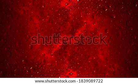 rain droplets falling on the glass, a rainy day in autumn, red background