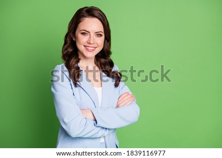 Photo of charming lady curly hairdo folded hands toothy smile wear blue jacket isolated green color background