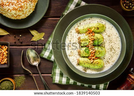 Arabic Cuisine; A delicious Lebanese stuffed zucchini in tangy garlic yogurt sauce. Served with cooked rice with vermicelli and topped with crispy pine nuts. Royalty-Free Stock Photo #1839140503