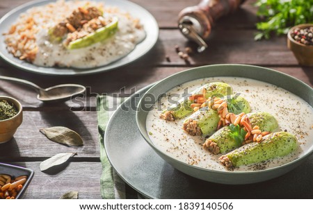 Arabic Cuisine; A delicious Lebanese stuffed zucchini in tangy garlic yogurt sauce. Served with cooked rice with vermicelli and topped with crispy pine nuts. Royalty-Free Stock Photo #1839140506