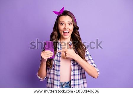 Photo of surprised girl point finger smartphone scream wear vintage checkered shirt isolated on purple color background
