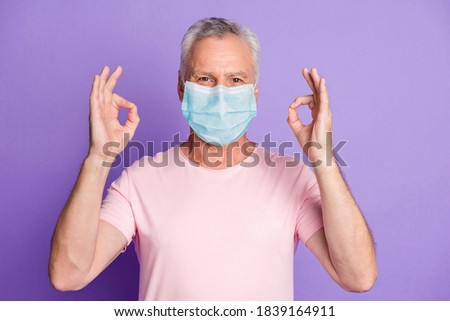 Photo of retired old man raise two hands show okey wear blue face mask isolated violet color background