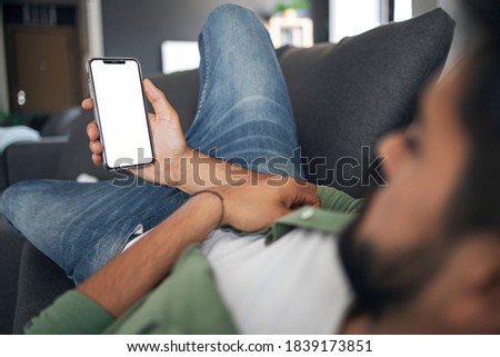 Male hand holding cellphone. White screen. Close up