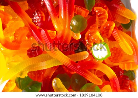 Closeup view of assorted colorful different shape jelly candies. Gummy worms and colorful jelly beans