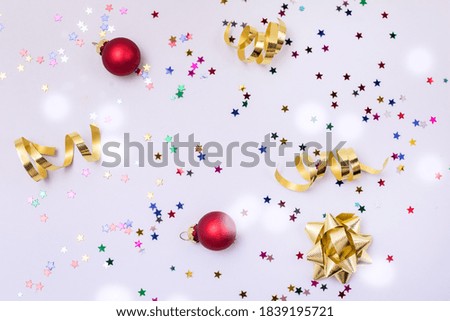 Confetti in Shape Stars Gold Ribbons Red Christmas Balls on Blue Background Festive Holiday Card or Background Top View Horizontal Drowing Snow