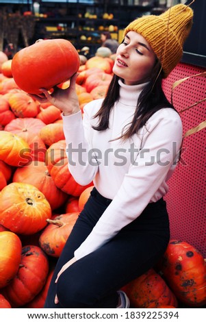 Fall photoshoot ideas. Planning for Thanksgiving. Fashionable beautiful young teen girl at the autumn pumpkin patch background.