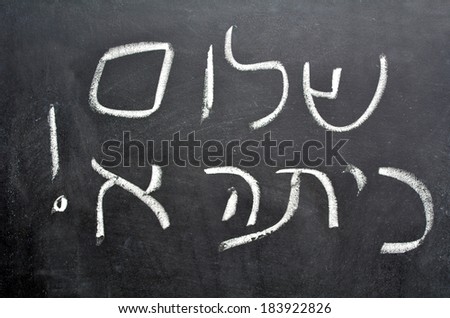 Hello First Grade greetings in Hebrew (Shalom Kita Alef) on a chalkboard in Israeli primary school at the beginning of the school year.Concept photo of early age education,learning ,studying, teaching Royalty-Free Stock Photo #183922826
