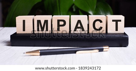 The word IMPACT is written on the wooden cubes of the diary near the handle.