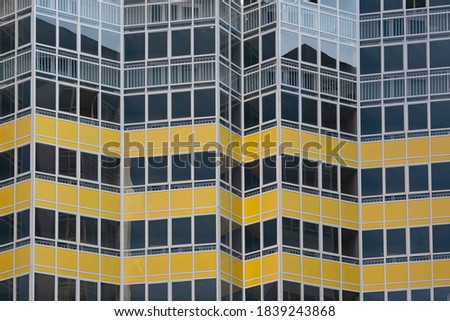 Glazing of the facade of a multi-storey building. Transparent windows with yellow accents. Background texture. Royalty-Free Stock Photo #1839243868
