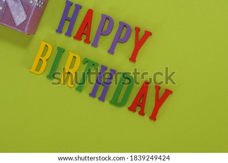 HAPPY BIRTHDAY word with gift box on green background