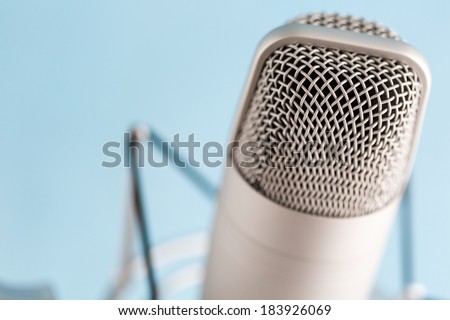 Studio microphone for recording podcasts on a blue background.