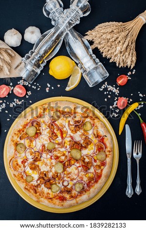 
Vertical photography - pizza from above on a plate with pepper and salt decor.