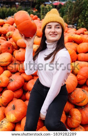 Fall photoshoot ideas. Planning for Thanksgiving. Fashionable beautiful young teen girl at the autumn pumpkin patch background.