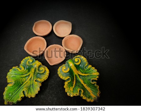 Clay oil lamp or diya used in india on  diwali festival decorate , group of diya on black background arranged in pattern .