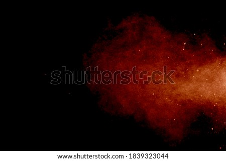The movement of abstract dust explosion frozen orange on black background. 