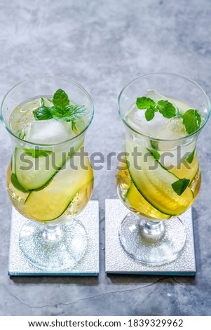 Elderflower and apple juice mocktail with cucumber, mint and ice cubes - refreshing summer non alcoholic drink