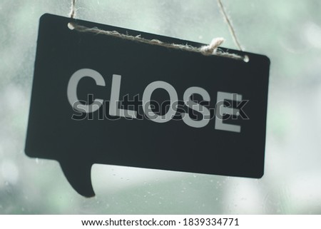 Closed sign board through the glass of door in the cafe