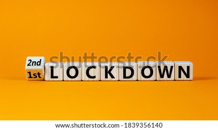 Symbol for a second lockdown. Turned cubes and changed the expression '1st lockdown' to '2nd lockdown'. Beautiful orange background. Medical and covid-19 pandemic concept, copy space. Royalty-Free Stock Photo #1839356140