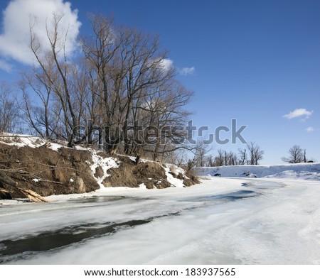 marvelous landscape in early spring on the river and white clouds on blue sky on a sunny day