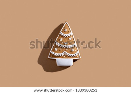Christmas tree cookies. Festive food bakery. Sweet homemade culinary. Gingerbread biscuit white icing ornament isolated on beige pastel background.