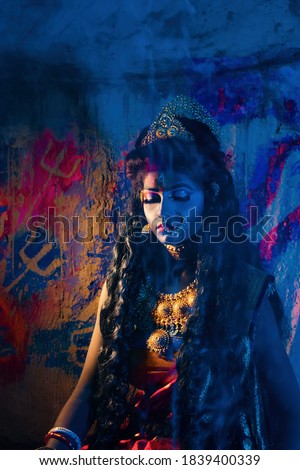 Concept Diwali  &  ‘KALI PUJA’ Festival shoot with black haired Indian brunette Bengali woman  wearing jewellery  like goddess  at a smoky place,

 Royalty-Free Stock Photo #1839400339