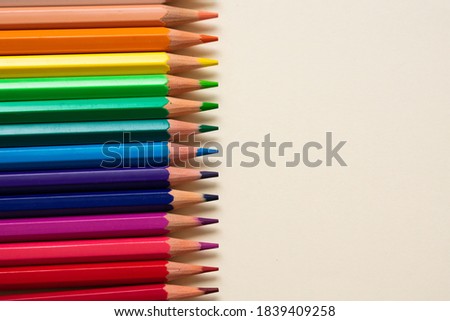 wooden color pencils all ordered in a gradient, on the left side of the image, with the right side full of copy space