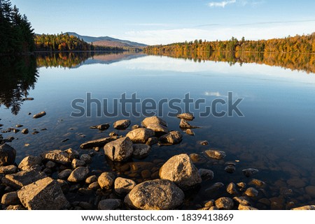 Morning sunlight lit rocks and beautiful lake and Autumn Trees
