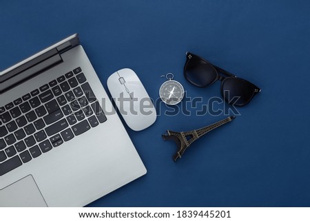 Flat lay vacation holiday and travel planing concept. Laptop and travel accessories on classic blue background. Top view