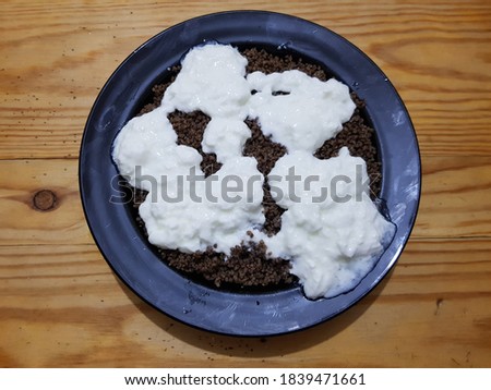 A bowl of couscous made from a mixture of barley and acorn with curd Royalty-Free Stock Photo #1839471661