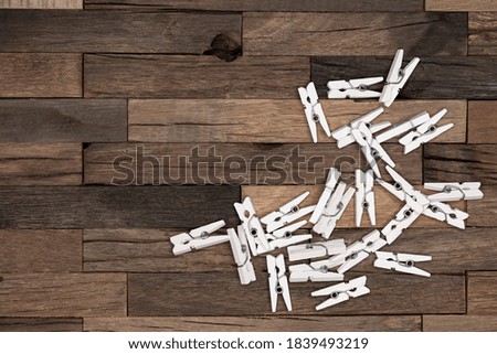 White clothespins on wooden background. Macro shot.