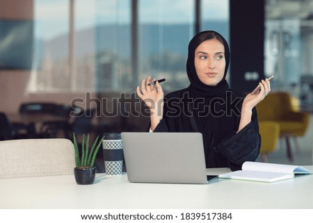 Pensive arabic businesswoman sitting at workplace in office