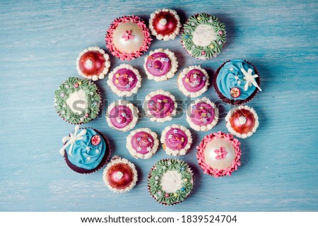 Very nice composition of cupcakes and cakepops with deocrations, colorful, blue background Chirstmas, xmas mood