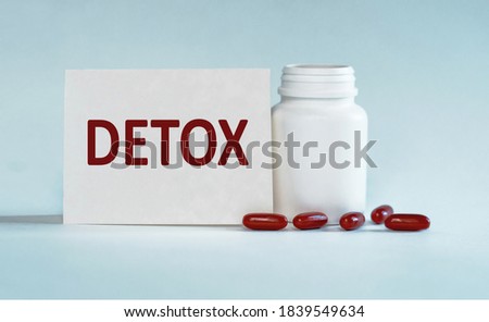 Detox written on a card near the bottle of pills, Medical concept