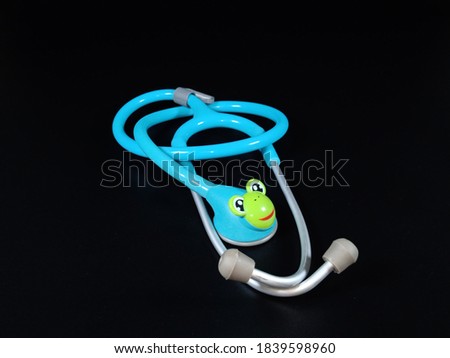 Medical Stethoscope with Cute Frog Head on Dark background. Health care concept. 
