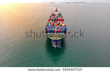 Aerial in front of cargo ship carrying container and running with Crew that working rope stand by for tug boat.