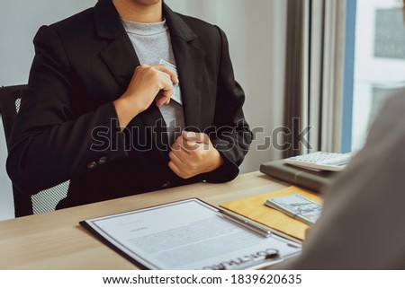 A female accountant or business woman is offering a bribe from her pocket to make an offer to a business man in a corporate office, bribery idea. And corruption