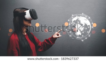 Concept of woman wearing VR glasses .Communication technology and internet worldwide for business concept.Woman hand holding Business World.