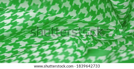 Silk fabric green pattern on a white background. A pattern on the fabric of a famous French fashion designer. Texture, background, pattern,