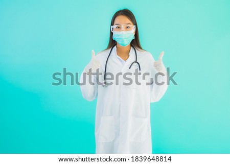 Portrait beautiful young asian doctor woman with mask work at clinic or hospital on blue isolated background