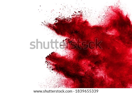 Red powder explosion cloud on white background. Freeze motion of red color dust  particles splashing.