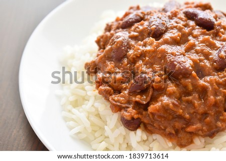 Chilli con carne with rice on a white plate.