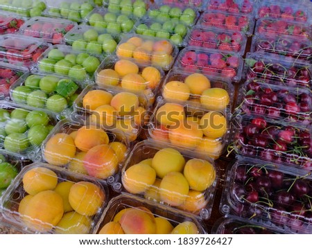 Fruits and berries close-up in plastic packaging for sale in supermarkets.Gardening, growing ripe berries and fruits. Dietary food.